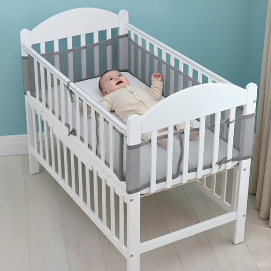 Bébé allongé et protégé par un tour de lit respirant gris