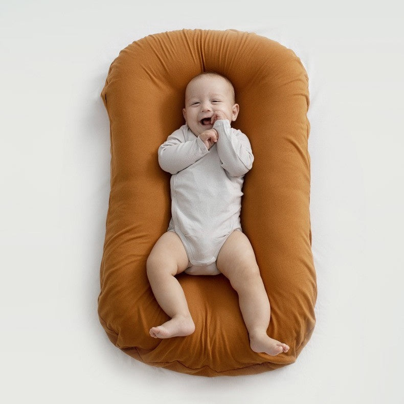 BEBE ALLONGE SUR UN REDUCTEUR DE LIT BIONICCOCOON™ BRUN CACAO