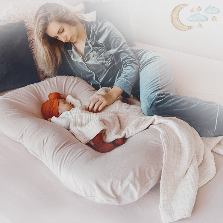 BEBE ENDORMI SUR UN REDUCTEUR DE LIT BIONICCOCOON™ GRIS BEIGE ET MAMAN