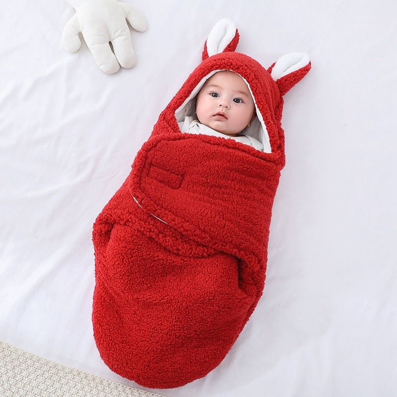 Bébé enveloppé dans notre couverture d'emmaillotage CuddleBunny™ rouge