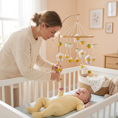 Maman fixant notre mobile bébé en bois fait main
