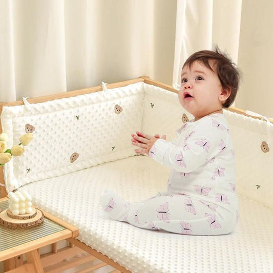 Bébé assis et protégé par un tour de lit bebe bulles douces