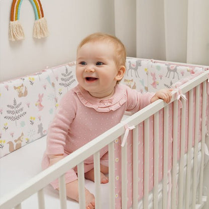 Bébé assise et protégée par le tour de lit Forêt rose
