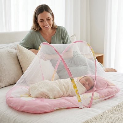 MAMAN SOURIANTE ET BEBE ENDORMI DANS NOTRE LIT MOUSTIQUAIRE BEBE ROSE