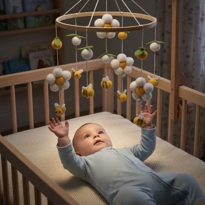 Bébé allongé avec notre mobile bébé en bois fait main