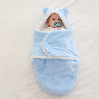 BEBE ALLONGE DANS NOTRE COUVERTURE D EMMAILLOTAGE ANIMALSNUGGLE™ OURS BLEUE