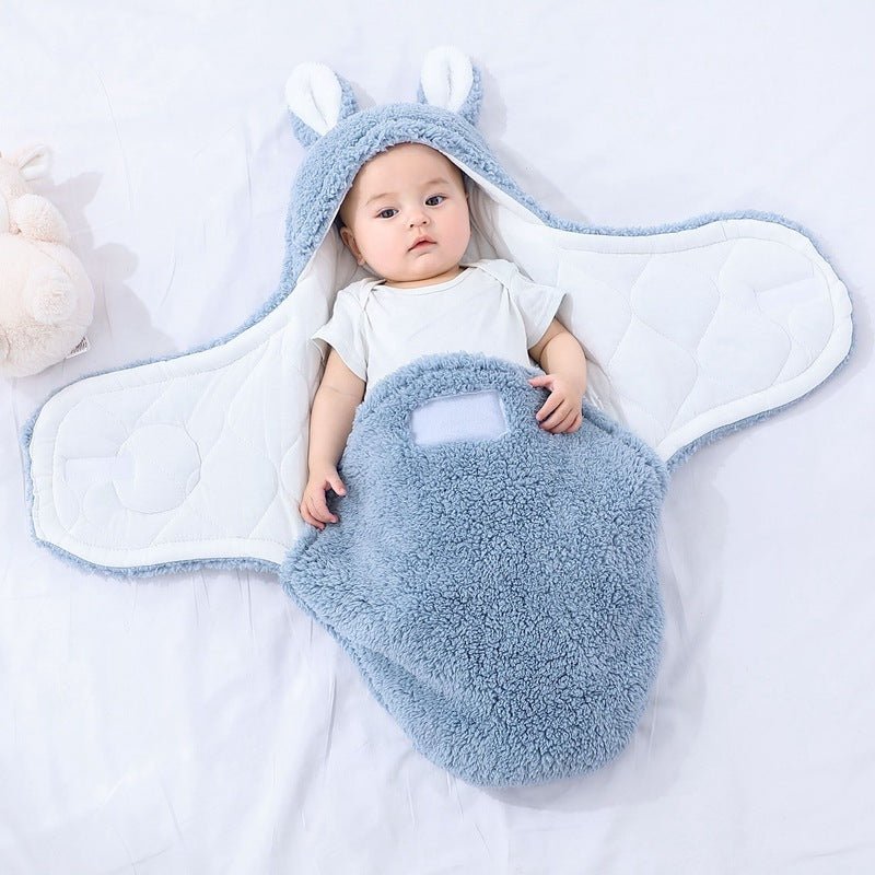 Bébé allongé dans notre couverture d'emmaillotage CuddleBunny™ bleue