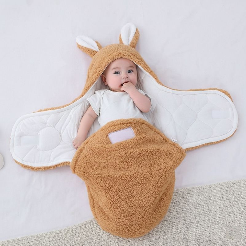 Bébé allongé dans notre couverture d'emmaillotage CuddleBunny™ caramel