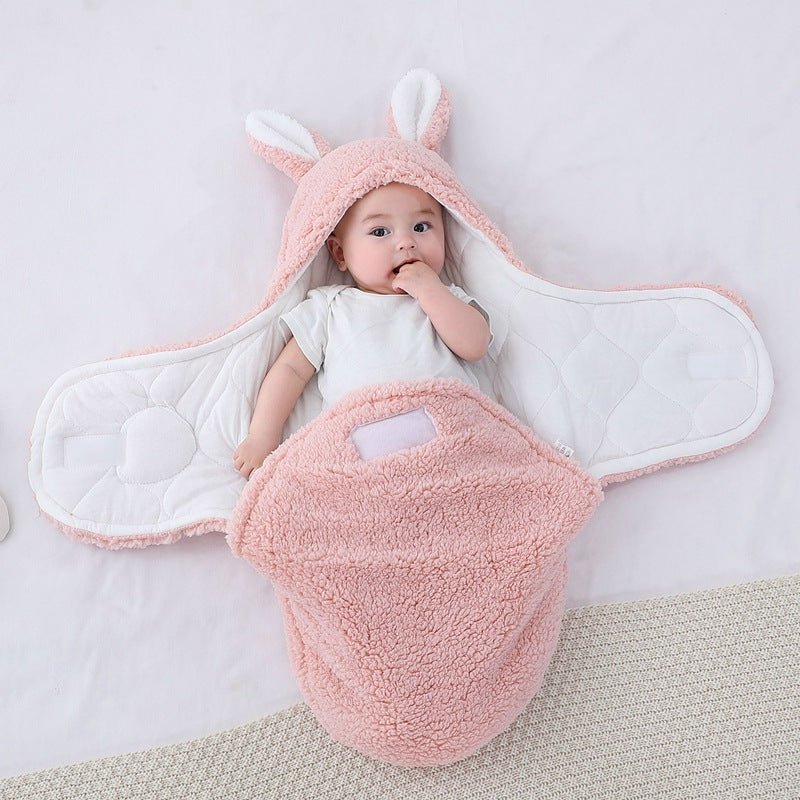 Bébé allongé dans notre couverture d'emmaillotage CuddleBunny™ rose