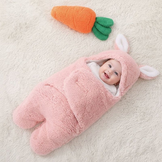 Bébé allongé dans notre emmaillotage couverture CuddleBunny™ rose