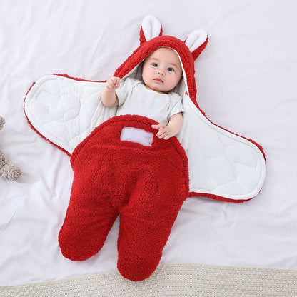 Bébé allongé dans notre emmaillotage couverture CuddleBunny™ rouge