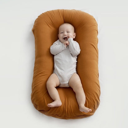 BEBE ALLONGE SUR UN REDUCTEUR DE LIT BIONICCOCOON™ BRUN CACAO