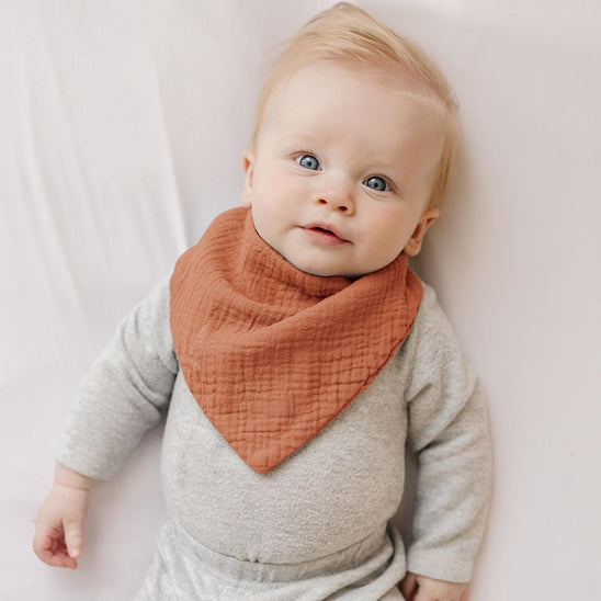 Bébé avec le bavoir bandana orange Cowbaby™