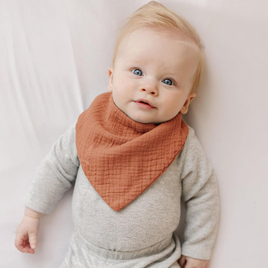 Bébé avec le bavoir bandana orange Cowbaby™