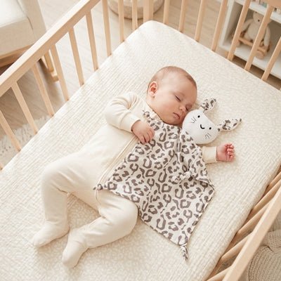 Bébé dormant avec notre doudou lapin Rabbib™ Léopard