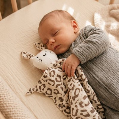 Bébé endormi avec le doudou lapin Rabbib™ Léopard
