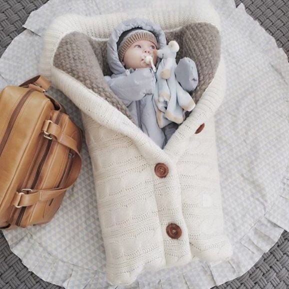 Bébé endormi dans notre couverture emmaillotage CuddleAngel™ blanche