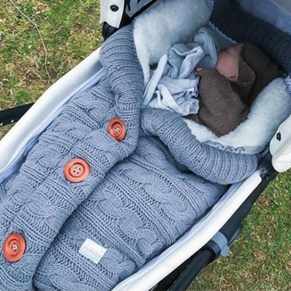 Bébé endormi dans notre couverture emmaillotage CuddleAngel™ bleue dans une poussette