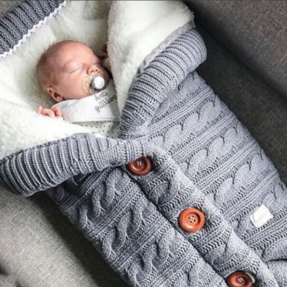 Bébé endormi dans notre couverture emmaillotage CuddleAngel™ grise