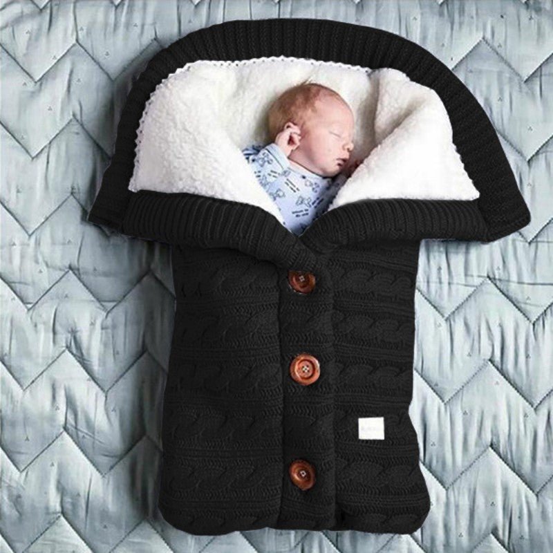 Bébé endormi dans notre couverture emmaillotage CuddleAngel™ noire