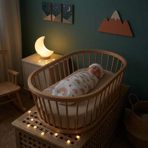 Bébé endormi sereinement dans notre Couverture emmaillotage confortable avec bonnet assorti