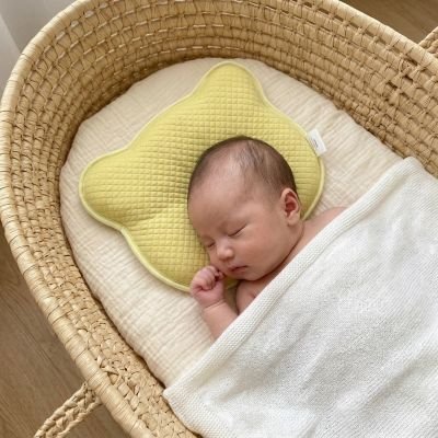 Bébé endormi sur notre coussin bébé anti-tête plate ergonomique et respirant jaune