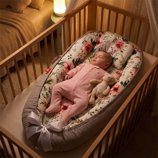 Bébé endormi sur notre réducteur de lit bébé nid fleuri dans son berceau