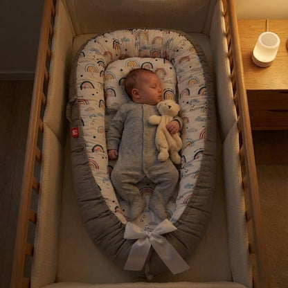 Bébé endormi sur notre Réducteur de lit NidPortableBébé™ - Arc En Ciel dans son berceau