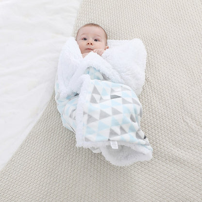 Bébé enveloppé par une Couverture bébé Double-face Sherpa triangle bleue