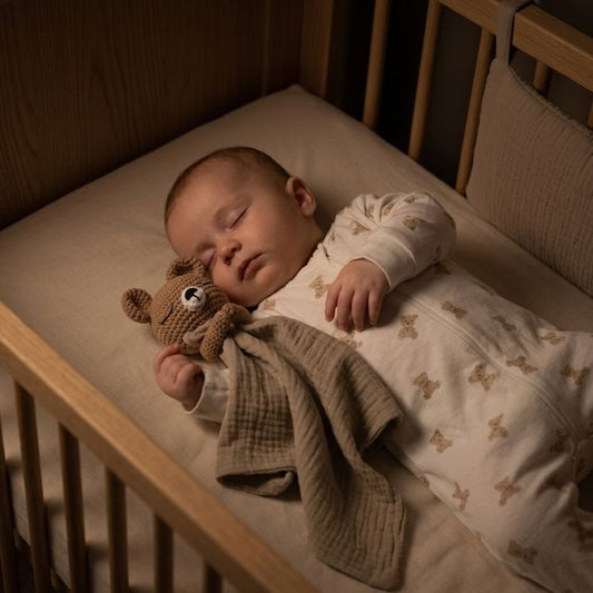 Bébé et notre doudou Ourson Rêveur dans un berceau