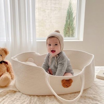 Bébé souriant assis dans Notre Couffin bébé CozyRope™