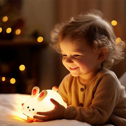 Bébé tenant notre veilleuse bébé BigFaceRabbit™