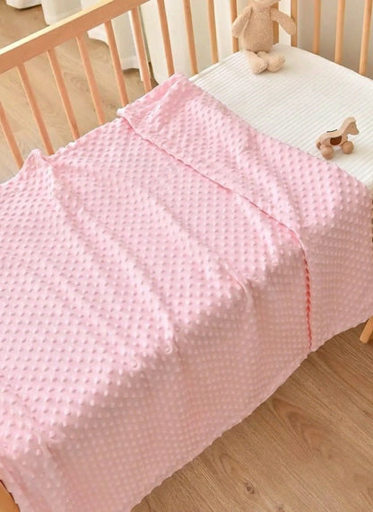 Couverture bébé Bulles douces rose sur un lit