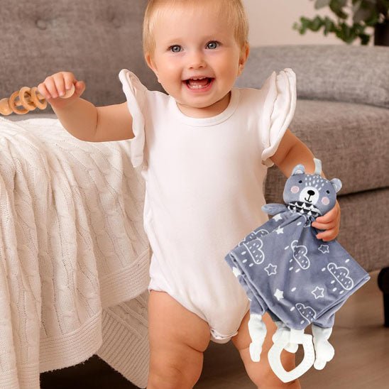 Fillette souriante jouant avec notre doudou animal ours