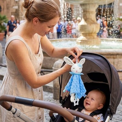 Maman accrochant notre doudou lapin Lapinea™ bleu sur une poussette