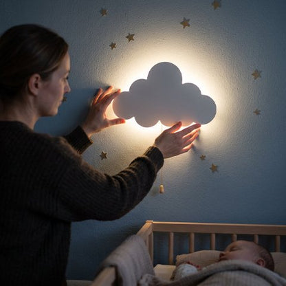 Maman ajustant notre veilleuse murale au chevet de bébé