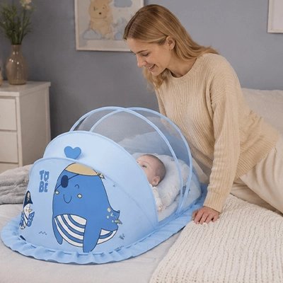 Maman regardant son bébé dans la Moustiquaire lit bébé