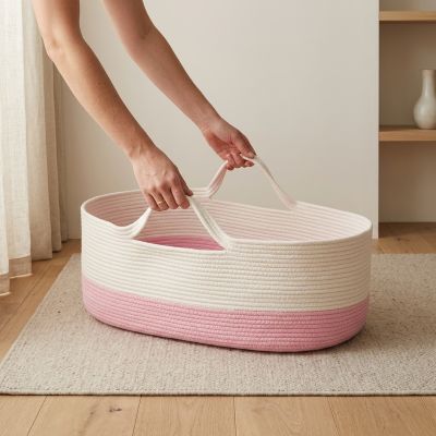 Maman tenant les poignées de notre Couffin pour bébé fille en corde de coton tressé rose et blanc