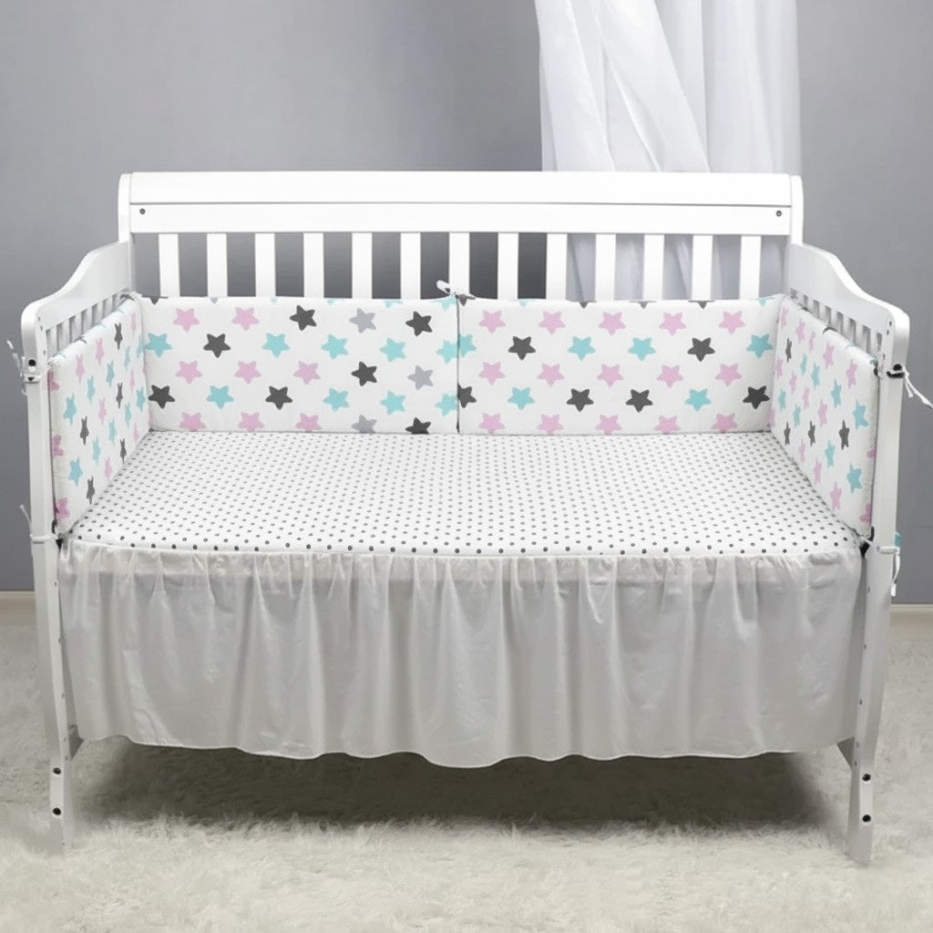 Bébé endormi et protégé par un tour de lit bébé harmonie d'étoiles rose