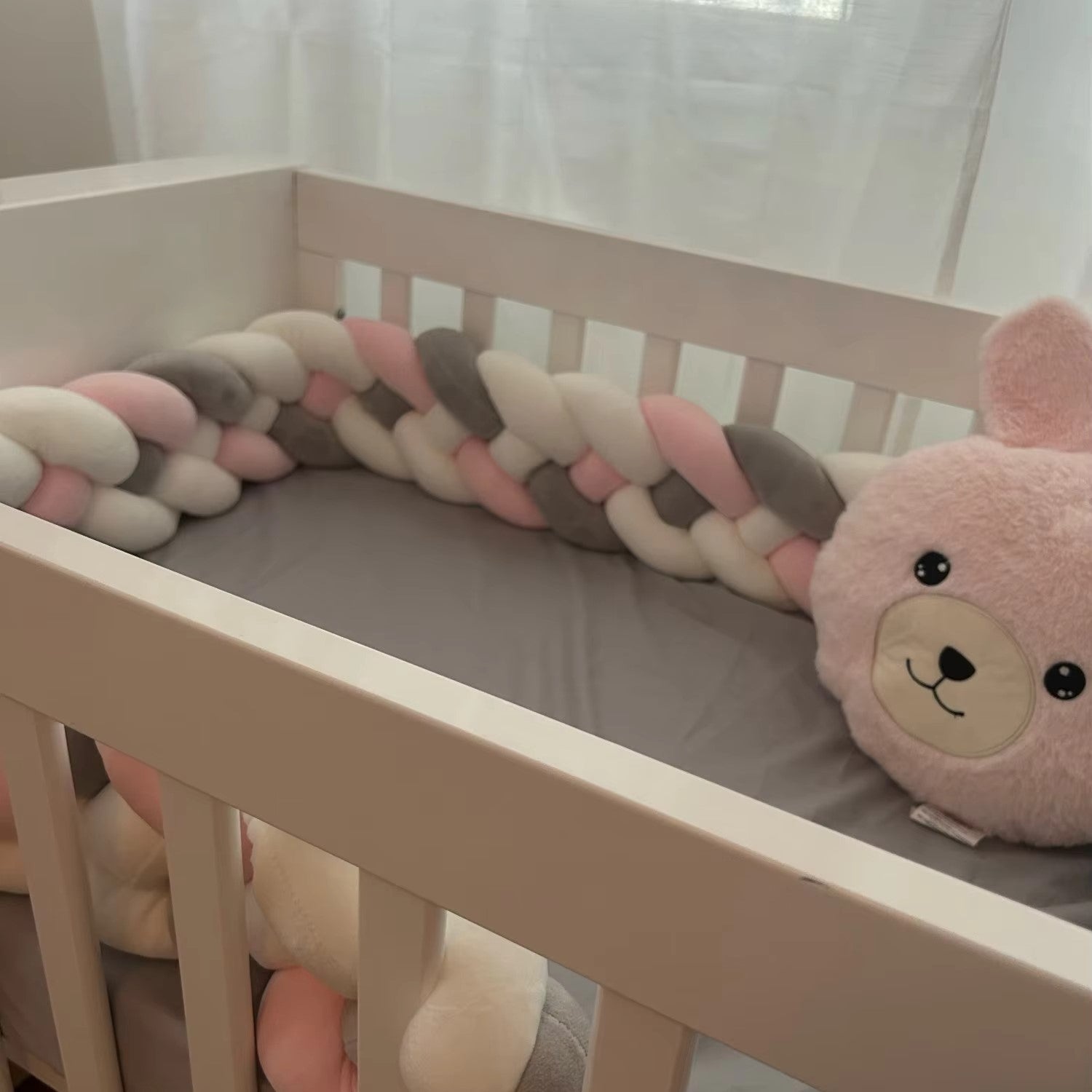 TRESSE DE LIT BEBE Rose Gris Blanc CozyKnot™ dans un berceau