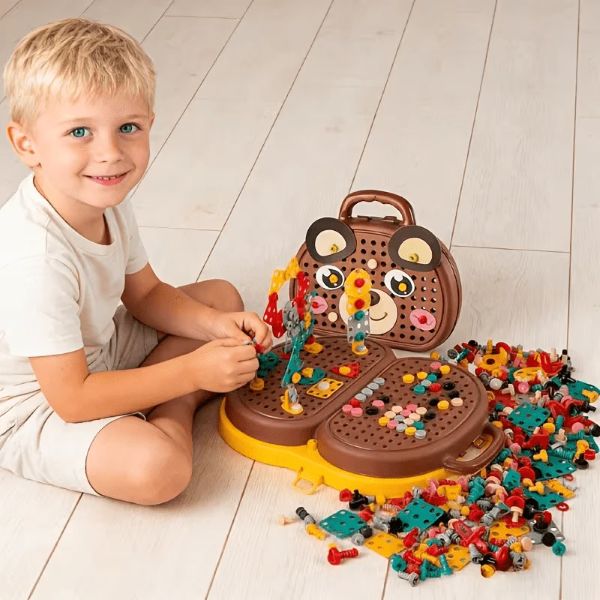 Un enfant souriant jouant avec notre boîte à outils Montesorri BricoBoxKid™